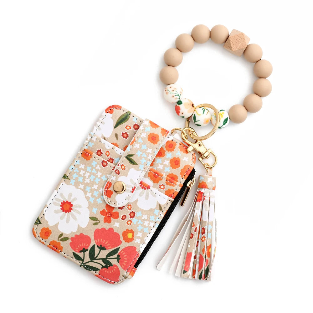 A silicone bead and PU leather key chain wallet with floral patterns and a wooden bead keyring.