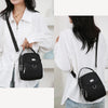 Une femme porte un sac à bandoulière floral noir sur une chemise blanche.