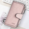A pink leather zipper wallet with a rounded edge and the word forever embossed on it, placed next to a white laptop keyboard.