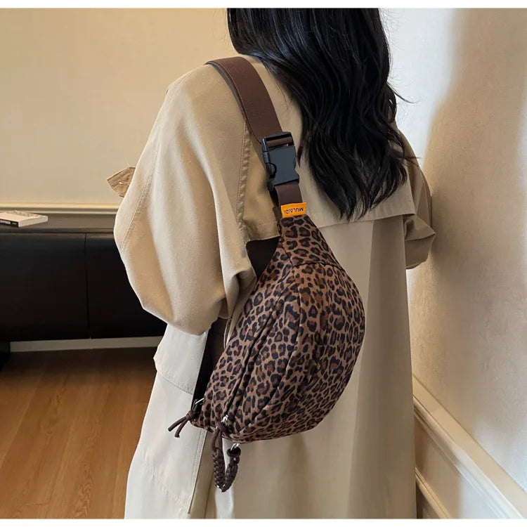 A beige oversized shirt features a leopard print crossbody bag with a brown leather strap.