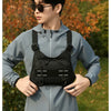 A young man wearing a gray tactical chest rig vest bag while standing outdoors.