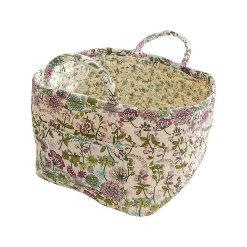 A quilted fabric storage basket with carry handles featuring a floral pattern.