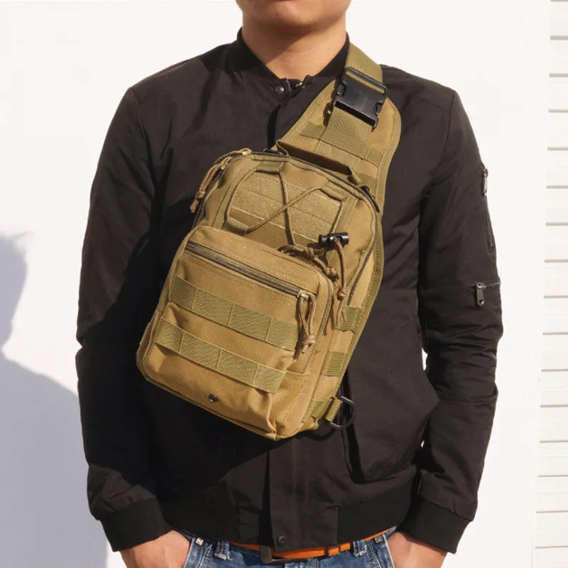 A person wearing a black shirt holds a tan tactical sling backpack.