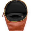 A brown PU leather crossbody sling bag with a black interior and gold-colored zipper details.