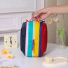 A vertical travel makeup bag featuring bright dopamine colors like blue, green, yellow, and red, resting on a white surface.