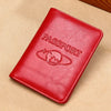 A red genuine leather passport holder with a globe emblem resting on a beige surface.