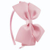 A pink satin bow headband with a ribbon tied in a large bow.