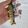 A silver necklace featuring a simulation fish charm with colorful beads and a star pendant.
