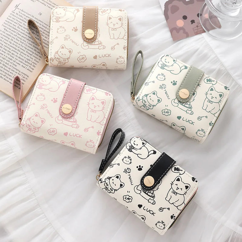 A collection of cute cat cartoon coin purses and card holder wallets in various pastel colors and patterns.