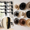 A collection of black magnetic wall hooks designed for hanging hats and accessories.