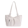 A light pink retro polka dot shoulder tote bag with a white strap.