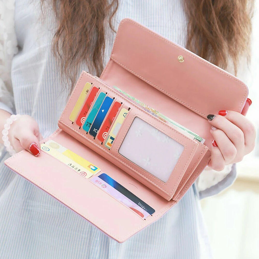 A pink quilted long wallet with a crown buckle is shown open, displaying various cards and cash.
