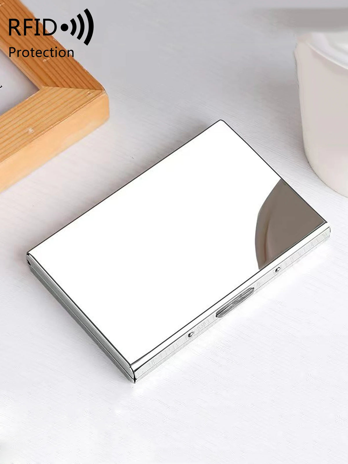 A silver stainless steel card holder with a protective cover is shown on a white surface.