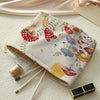 A makeup bag with a fairytale mushroom and butterfly print is shown next to makeup brushes.