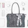 A gray vintage PU leather laptop tote bag with a patterned scarf and various accessories displayed on a white background.