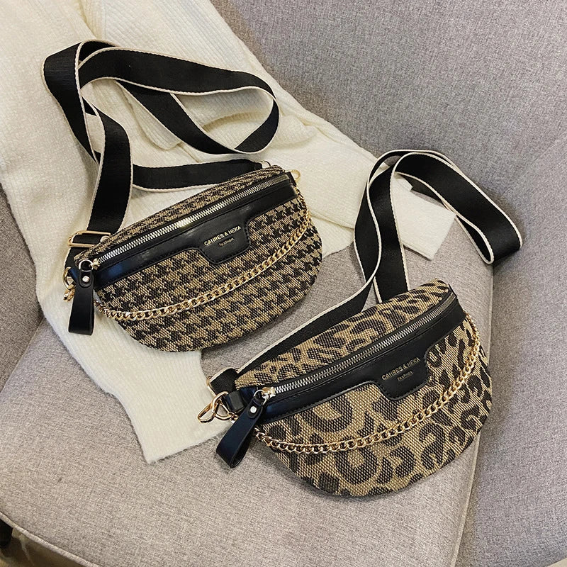 Sac bandoulière à taille imprimé léopard noir et or sur une surface gris clair.