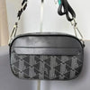 Schwarze Leder-Crossbody-Tasche für Herren mit geometrischem Muster vor hellem Hintergrund.