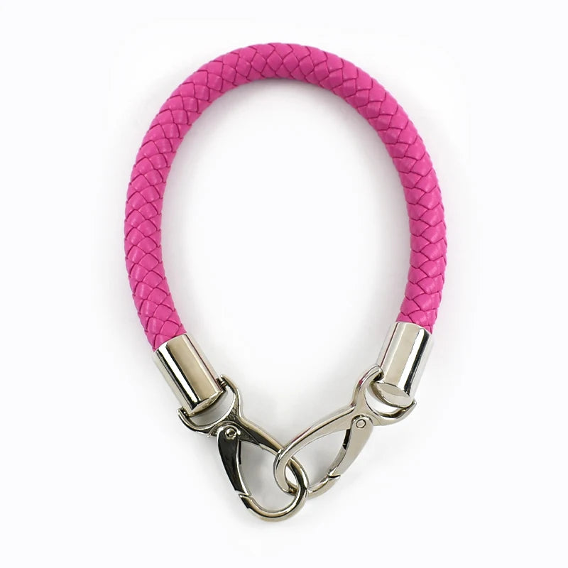 A pink faux leather strap with metal buckles for a bag or item.