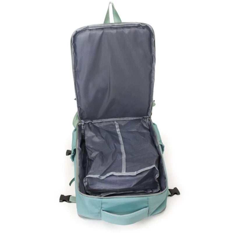 A dark blue compact travel backpack with a light green trim and straps, shown open.