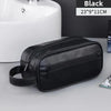 Black PU leather travel toiletry bag with organizer pockets shown on a gray surface.