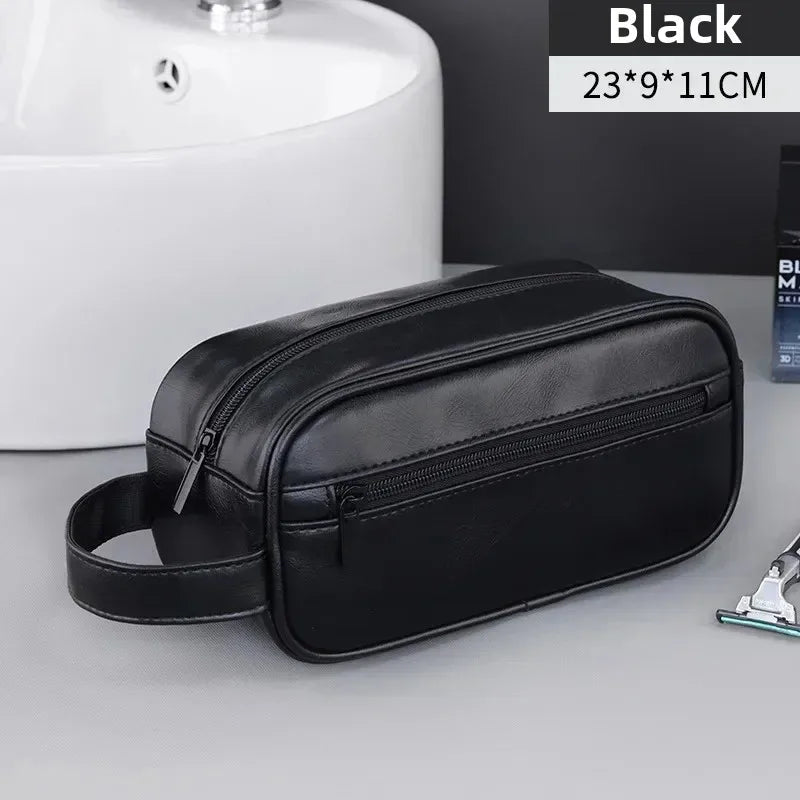 Black PU leather travel toiletry bag with organizer pockets shown on a gray surface.
