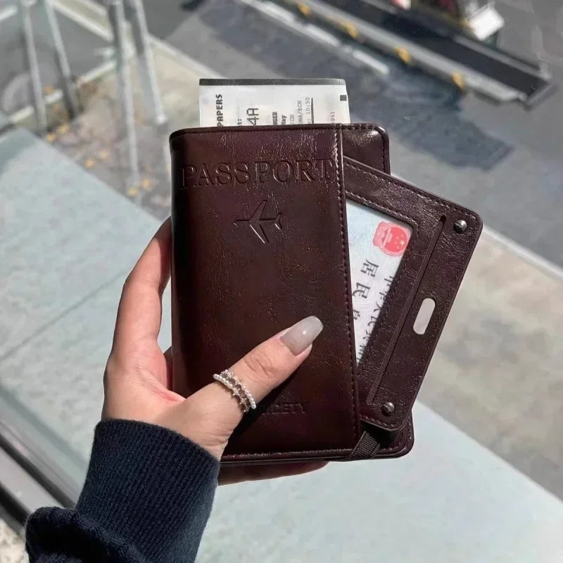 A hand holds a brown leather passport wallet with an RFID-blocking feature and a passport inside.