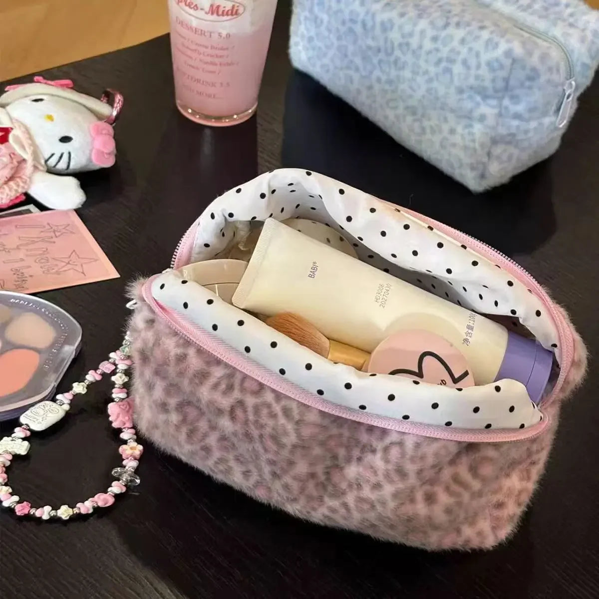 Una bolsa organizadora de cosméticos con estampado de leopardo peludo abierta, mostrando productos de belleza dentro.