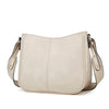 Sac à main en cuir PU beige clair avec fermeture à rabat et quincaillerie dorée.
