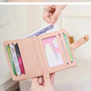 A light pink minimalist wallet is displayed, showing its interior with cards and IDs.