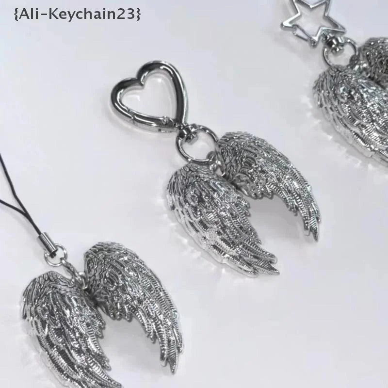 Silver metal angel wing keychain charm with a heart pendant
