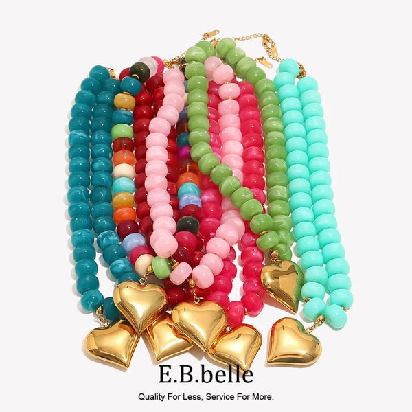 A colorful bead necklace featuring pink, red, green, and blue resin heart charms on gold-toned chains.