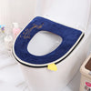 A dark blue plush waterproof toilet seat cover is shown placed inside a white toilet bowl.