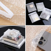 Several clear self-sealing bubble mailer bags with protective cushioning are shown on a black surface.