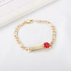 A gold chain bracelet with a red heart charm on a white background.