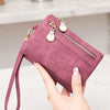 A hand holds a mauve retro PU leather double fold wallet with gold zipper pulls.