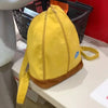 A yellow banana-shaped backpack with a brown trim is displayed on a white surface.
