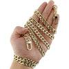 A hand holds a gold-colored metal chain strap for handbags and wallets.