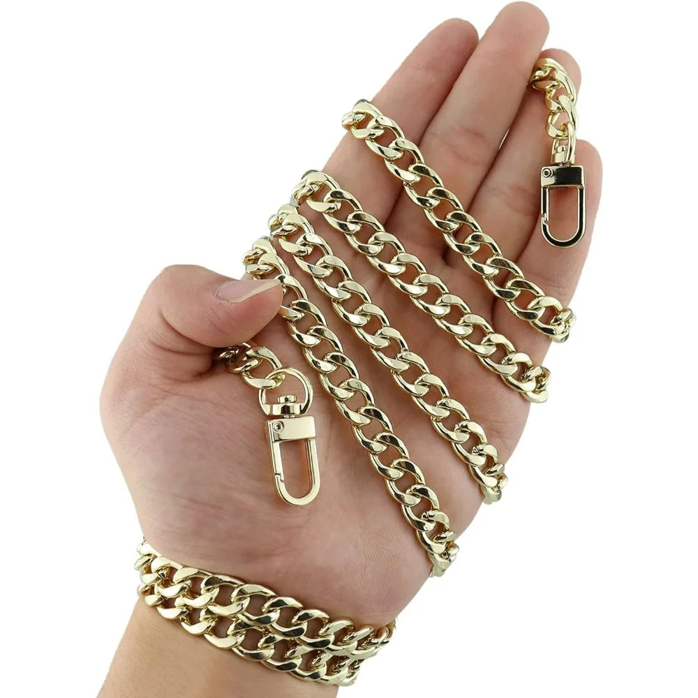A hand holds a gold-colored metal chain strap for handbags and wallets.