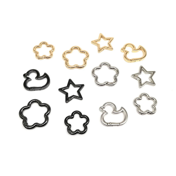 A collection of gold and silver star, duck, and flower shape carabiner clips.
