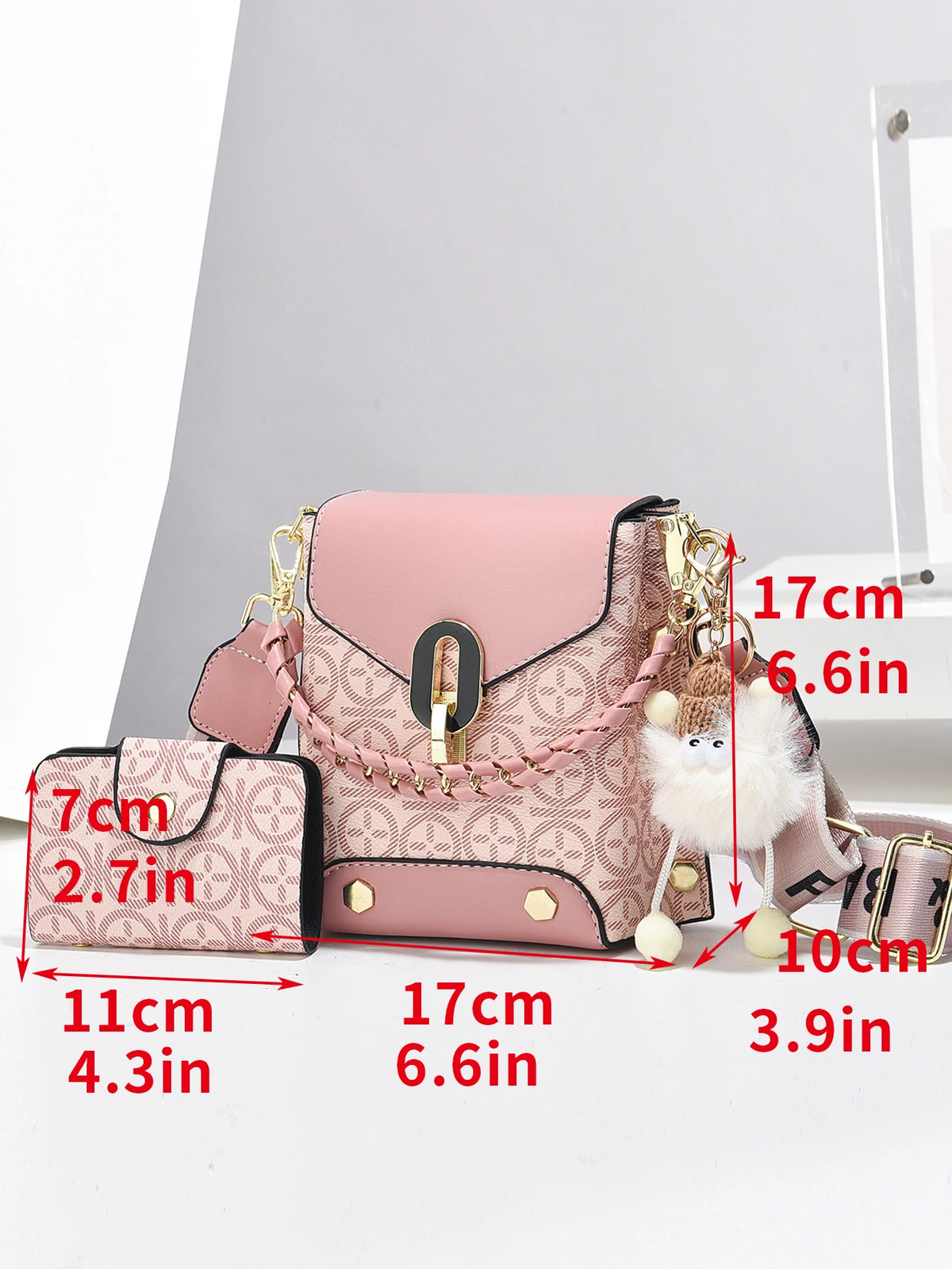 Sac bandoulière en similicuir rose avec quincaillerie dorée et un charm pompon moelleux.