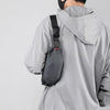 A person wearing a gray jacket is shown from the back, carrying a black water-resistant nylon waist bag.