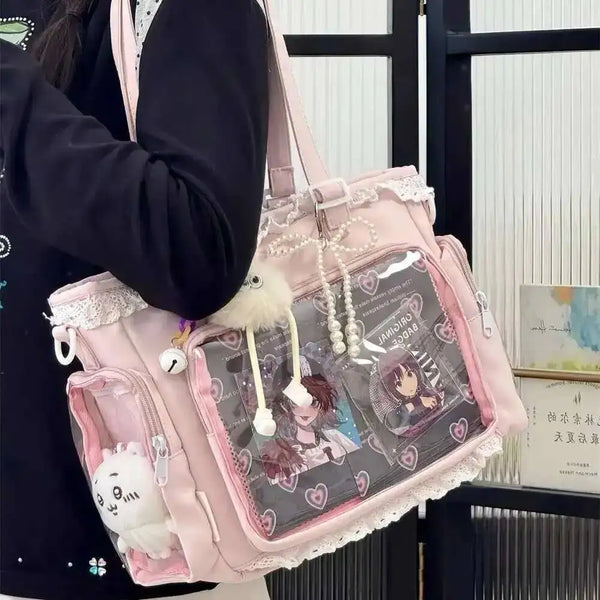 A pink transparent shoulder tote bag featuring a collage of anime characters and decorative strings.