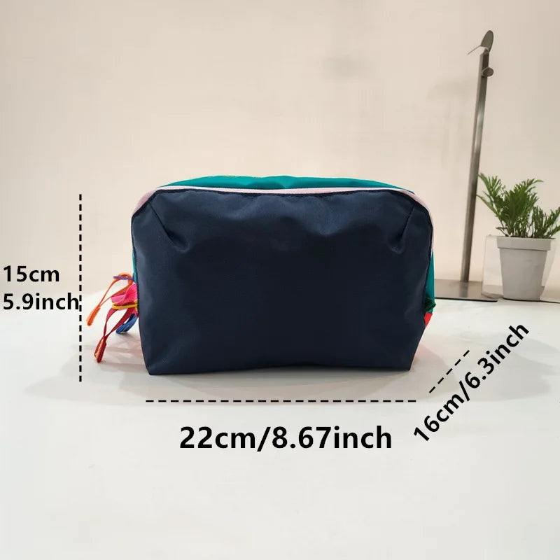 Navy blue lightweight travel makeup bag with teal trim shown on a white surface.
