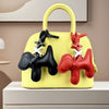 A yellow PU leather bag features a black puppy charm with a bow tie detail.