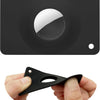 A hand holds a black MagSafe card wallet with a built-in AirTag pocket.