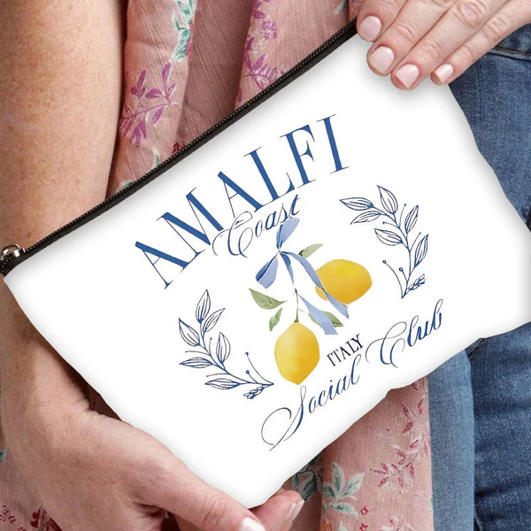 A white cosmetic storage bag with blue text reading Amalfi Italy Social Club and olive branch illustrations.
