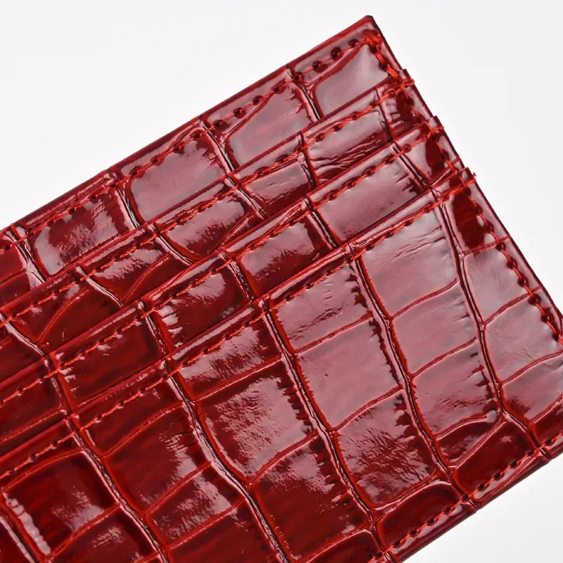A close-up of a reddish-brown crocodile embossed slim PU leather card holder wallet.