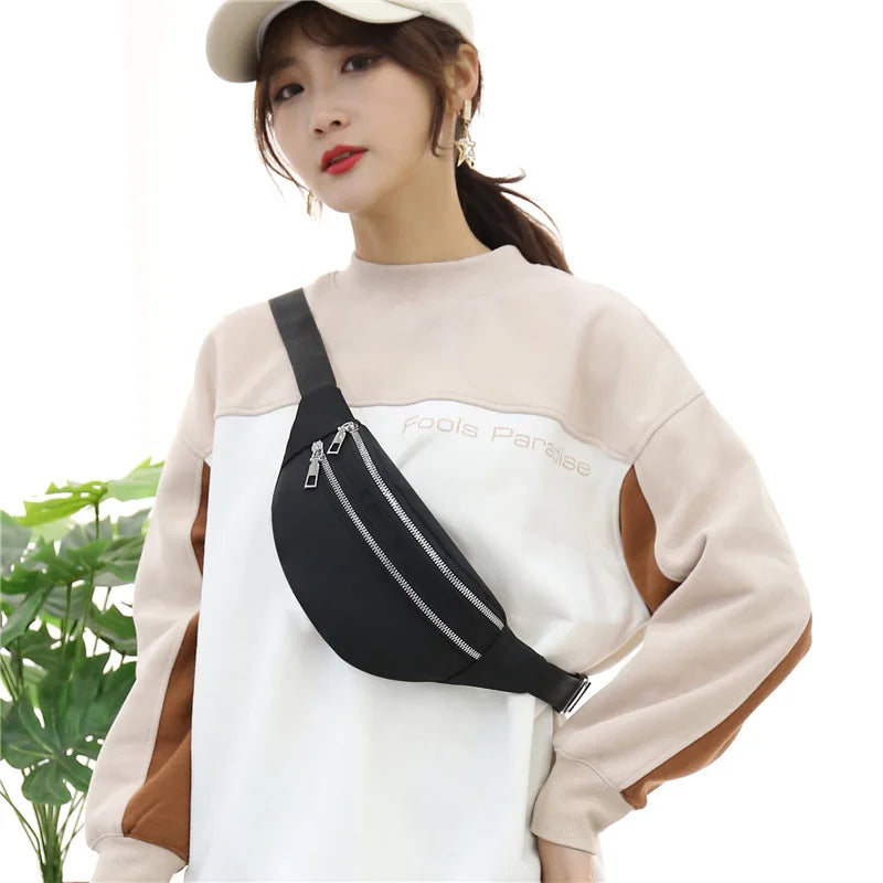A woman models an adjustable nylon crossbody sling bag in black and beige tones.