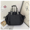 A black nylon shoulder bag with a striped handle and flap is displayed against a light background.