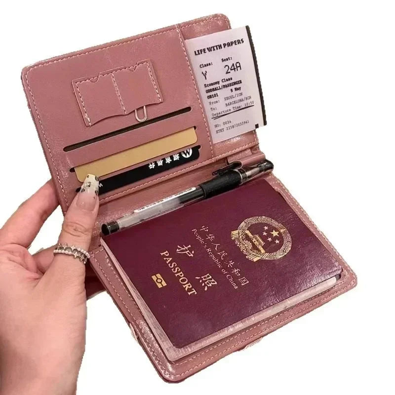 A hand holds an elegant pink passport wallet with RFID-blocking features and various cards inside.